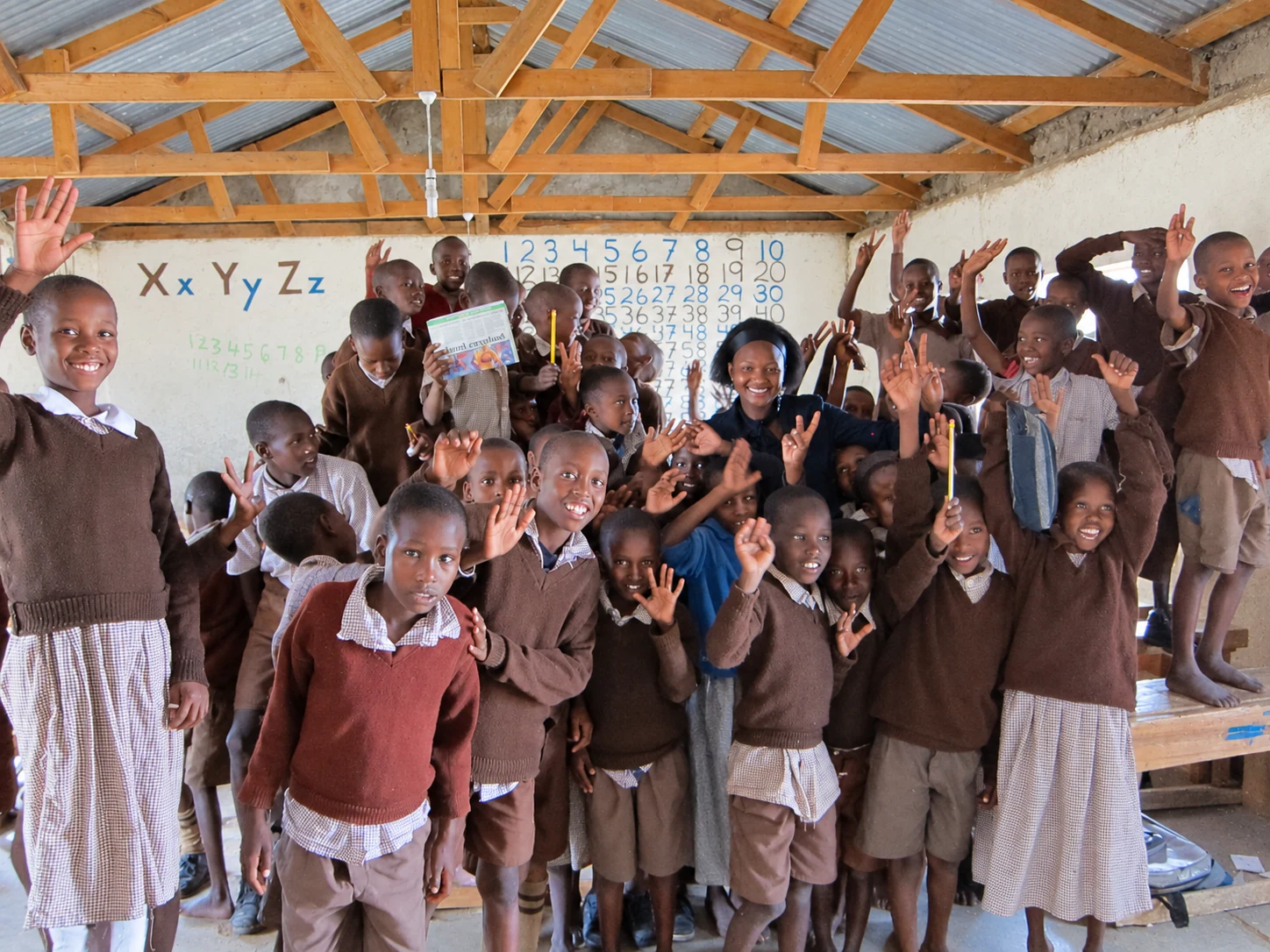 Students and an adult gathered inside a classroom.