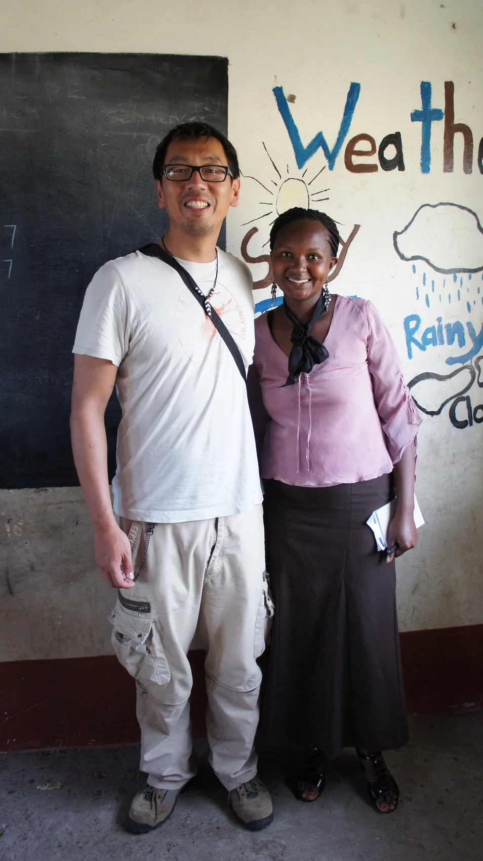 LBHS MUN leader Mr. Shen standing with another adult in a classroom during a school visit.